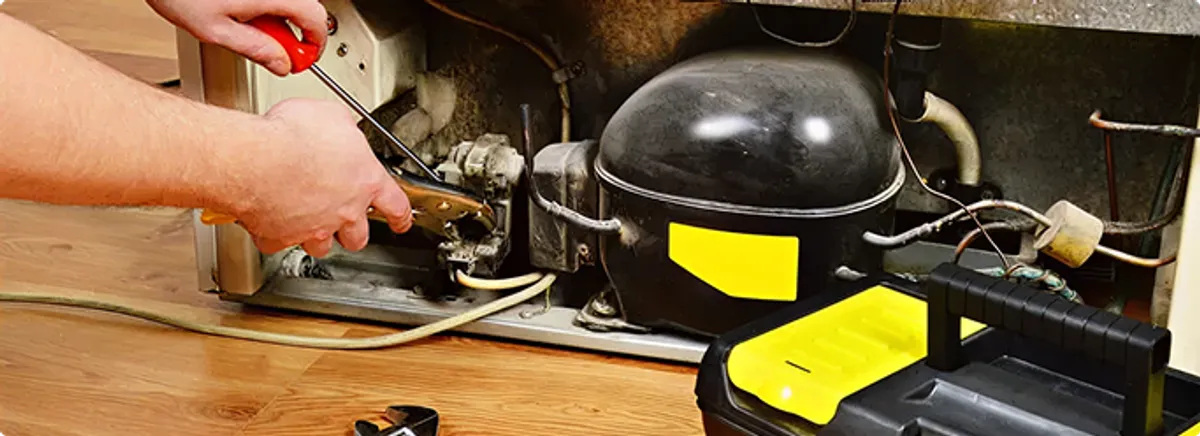 Refrigerator repair technician fixing the compressor and wiring in Sandston, VA