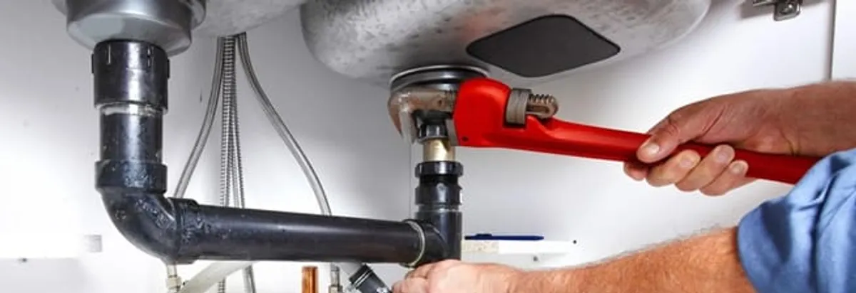 Garbage disposal repair technician tightening the sink drain and disposal connection in Richmond, VA