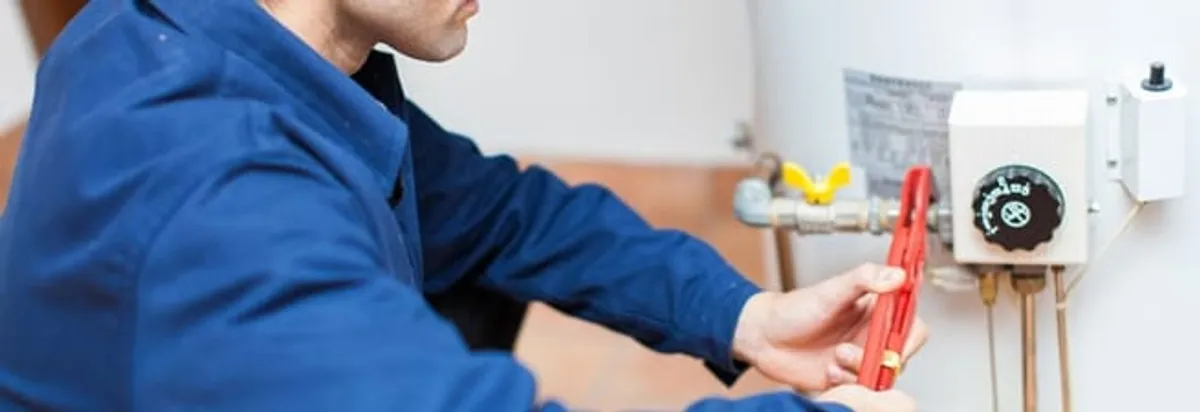 Water heater repair technician adjusting the temperature control and gas valve in Richmond, VA